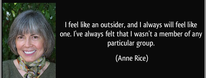 Gray-haired woman smiling on the left, wearing a green sweater and patterned scarf. On the right, a quote about feeling like an outsider by Anne Rice.