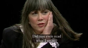 Anne Rice, 1997 Anne Rice on TV in the 1990s, with long dark hair resting her chin on her hand, looking thoughtfully at the camera, with the text and world famous author asking pointedly: "Did you even read what I wrote?"